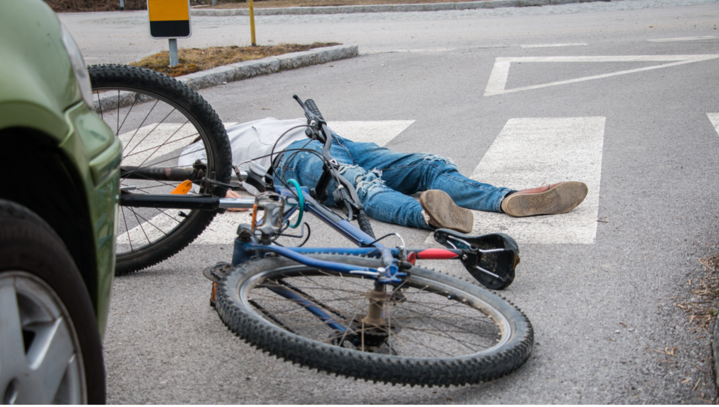 bicyclist lying in street after getting hit by car