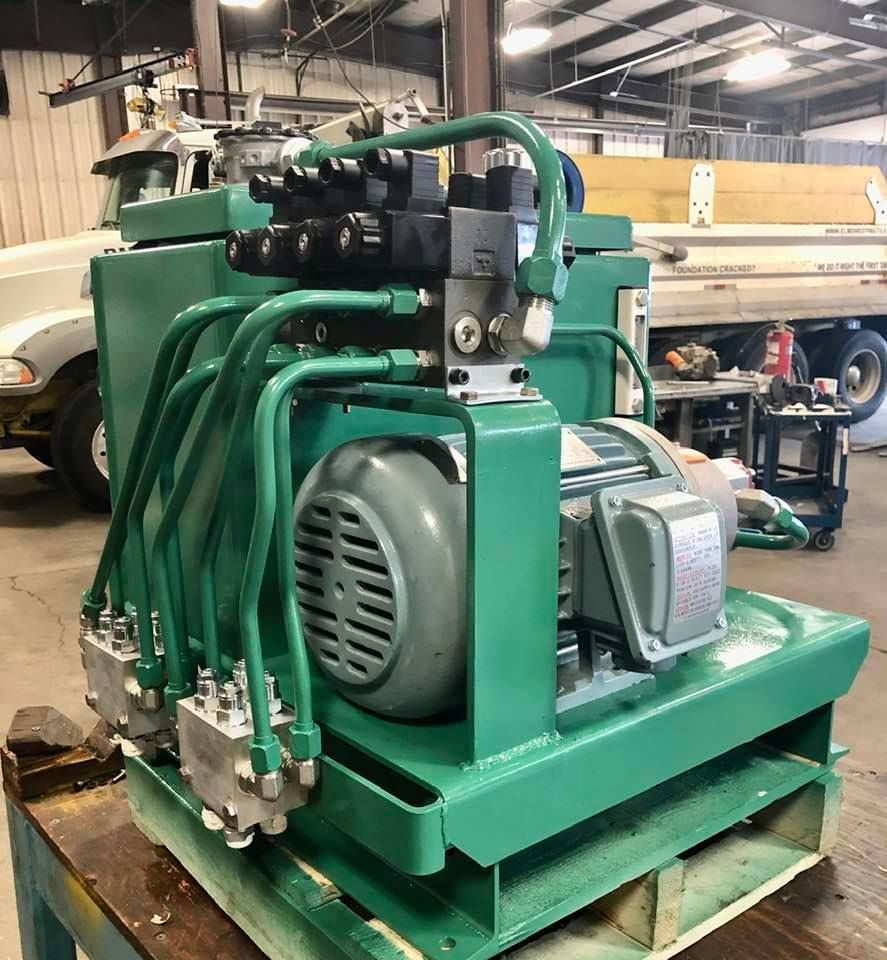 A machine is sitting on a cart in front of a garage door.