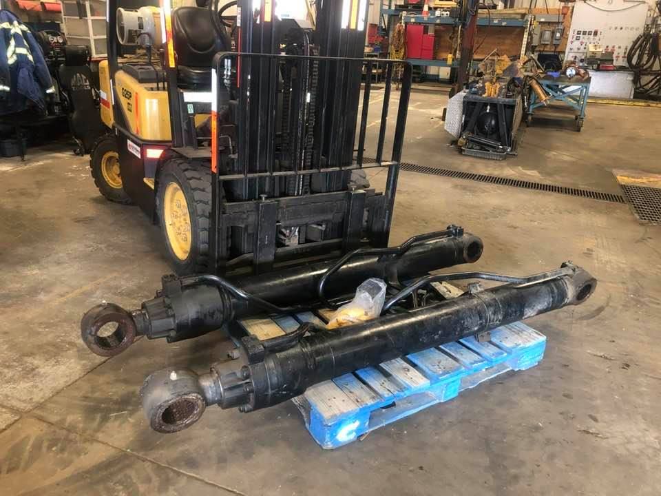 A red machine is sitting next to a black tank in a room.