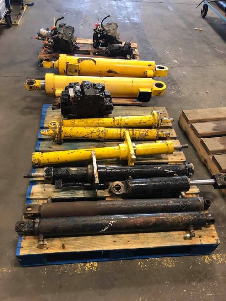 A woman is using a pipe bending machine in a garage.