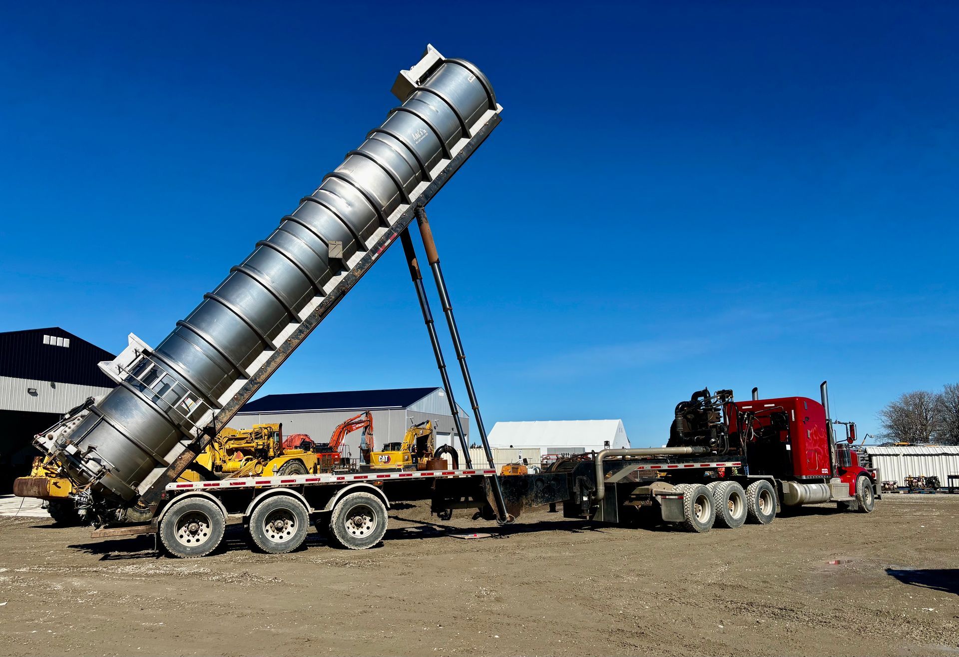 A woman is kneeling down next to a large yellow object.