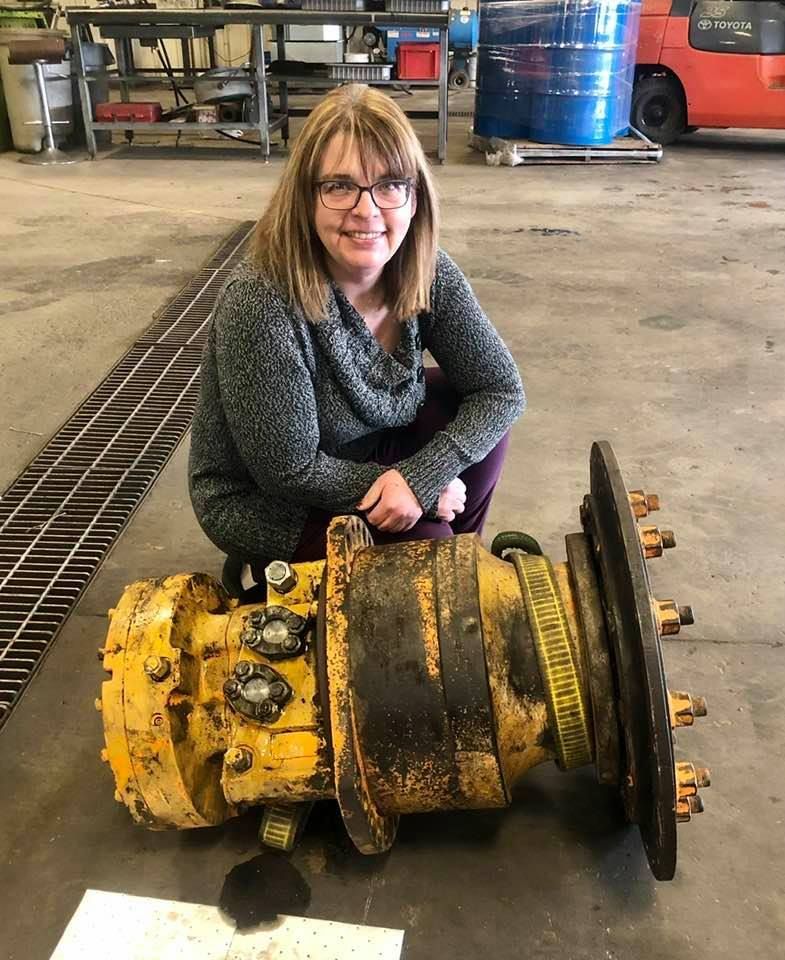 Two yellow cylinders are sitting on a wooden pallet on top of a forklift.