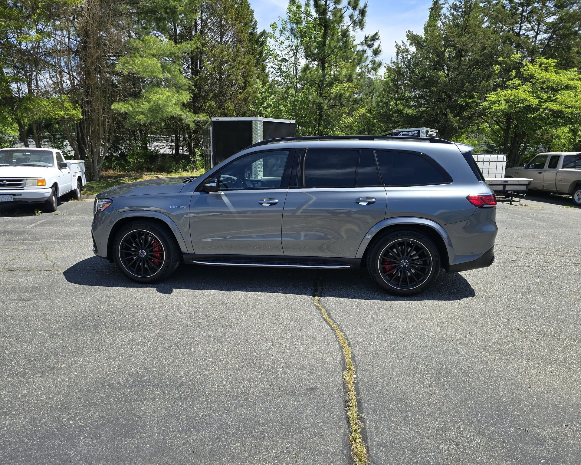 Gray SUV with black rims and red brake calipers parked on asphalt.