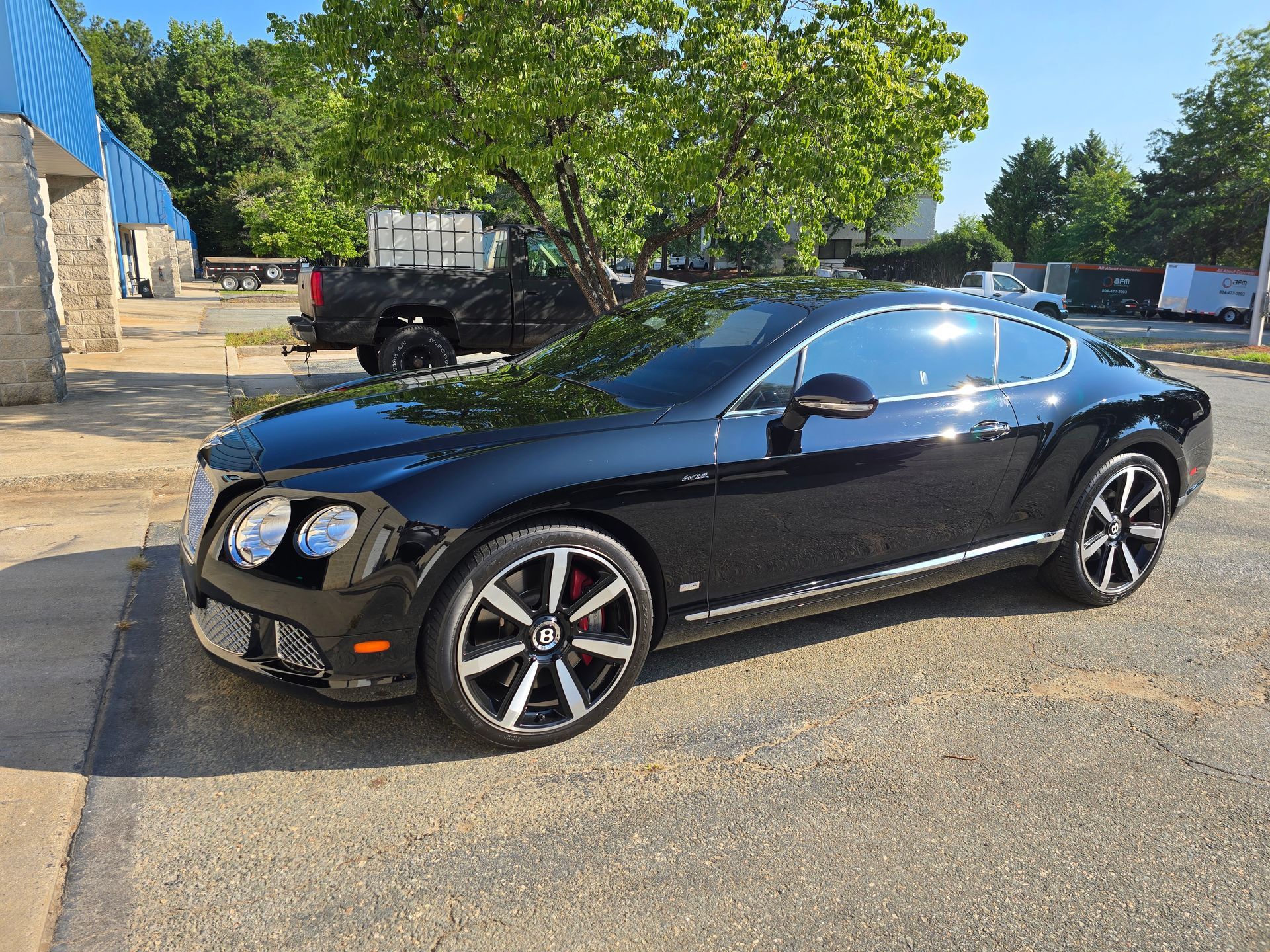 Black Bentley coupe parked on asphalt.