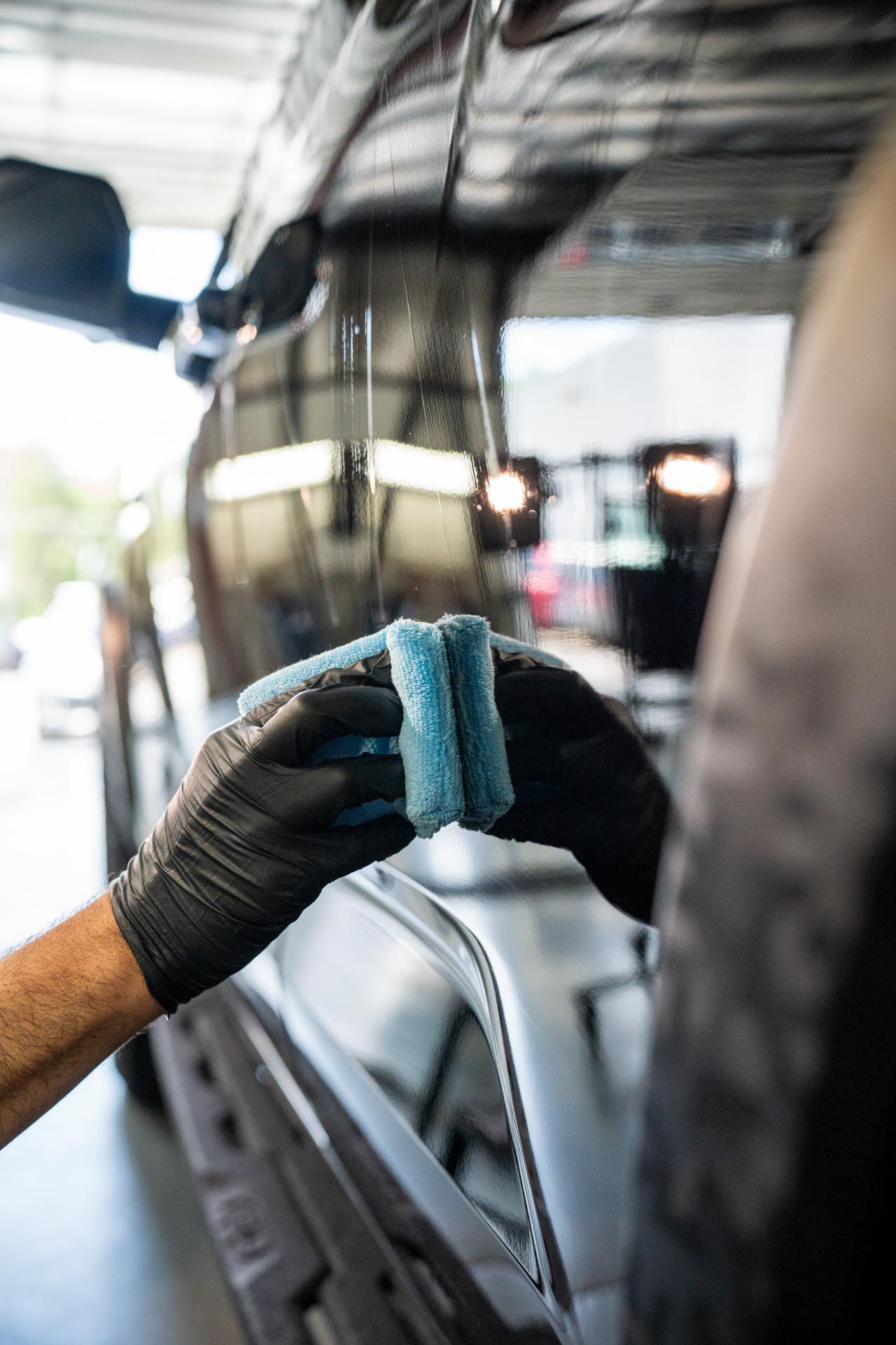 A person is cleaning a car window with a sponge .