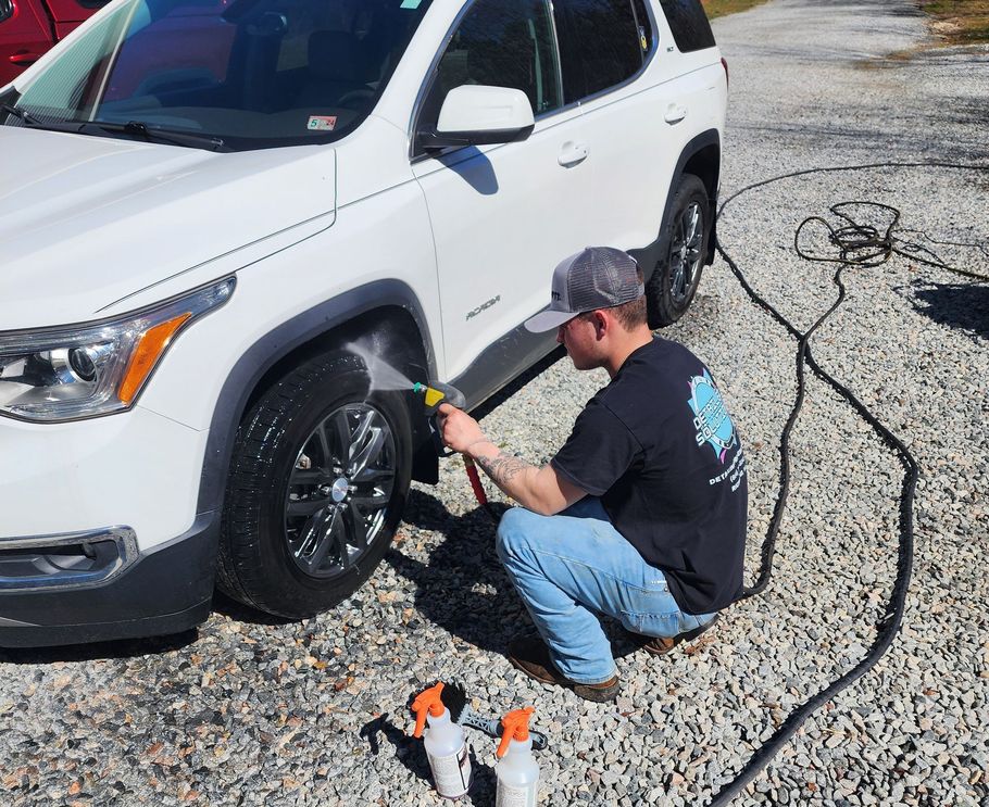 A person is cleaning the hood of a car with a cloth .