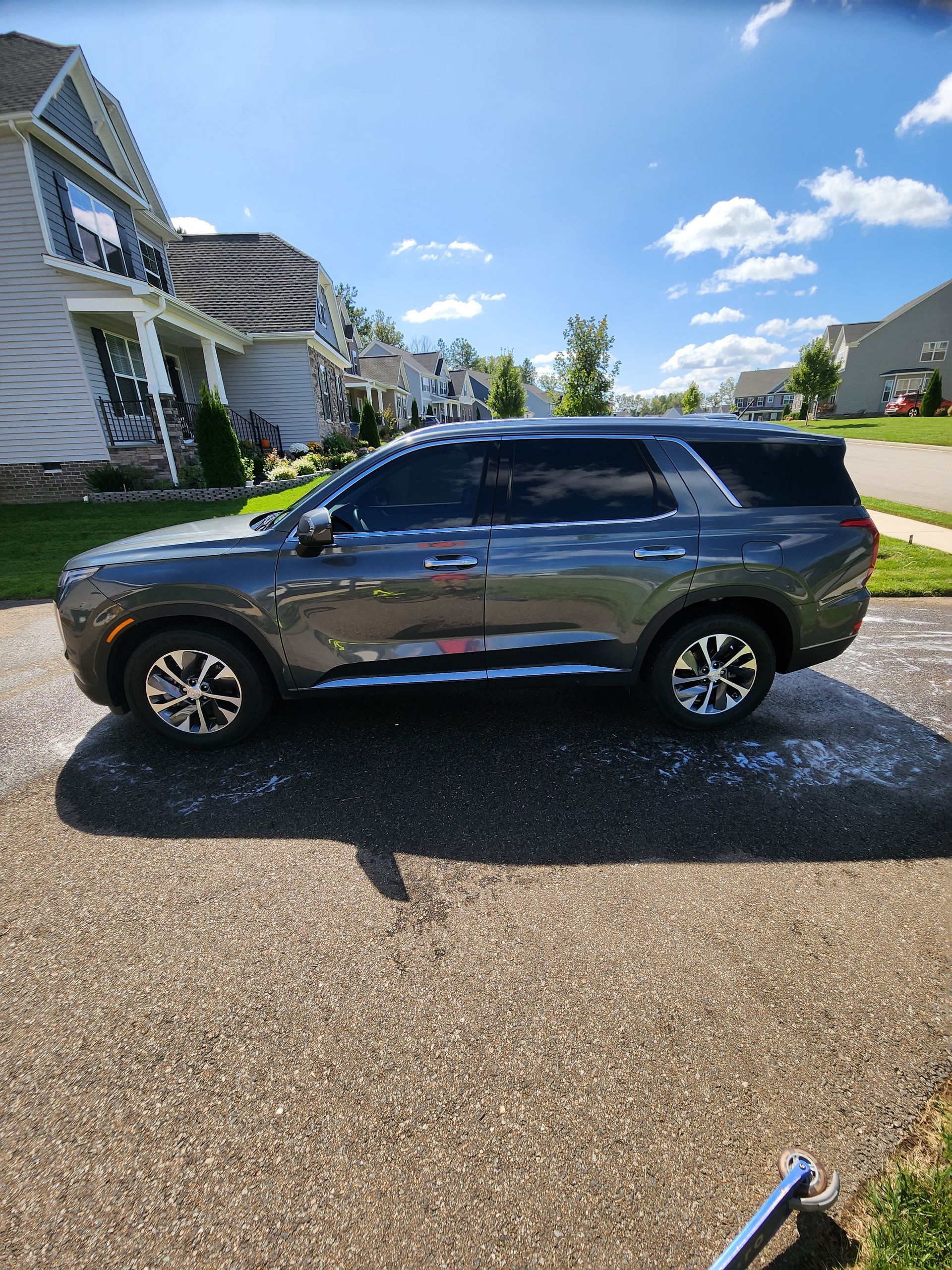 A gray suv is parked in a driveway in front of a house .