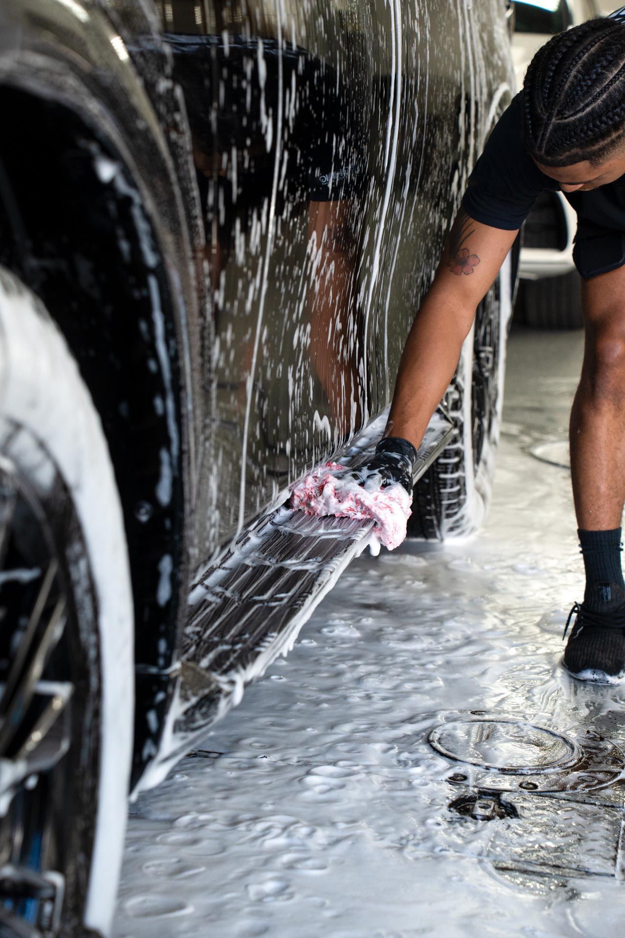 A man is washing a car in a car wash .