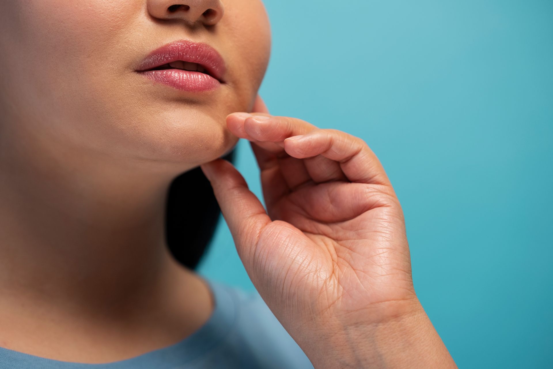 A woman is touching her chin with her hand.