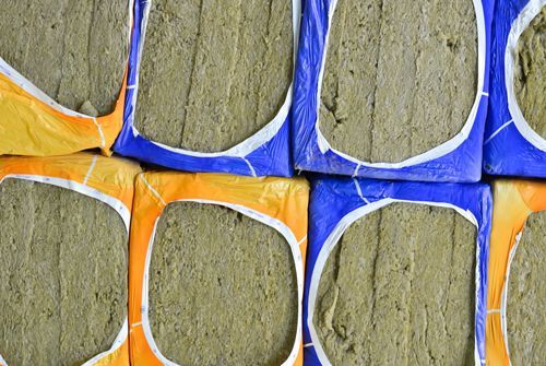 Close-up of packaged insulation blocks in blue and orange wrappers.