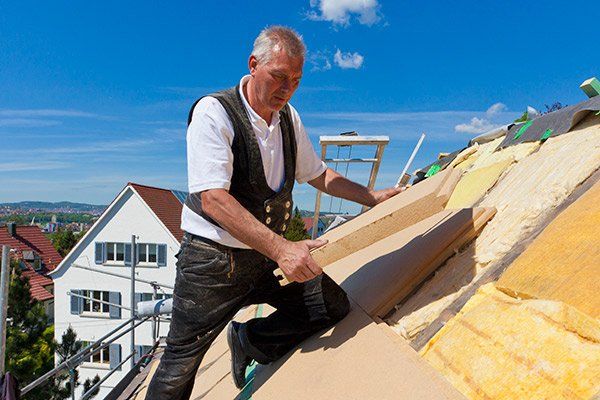 man installing insulation on roof