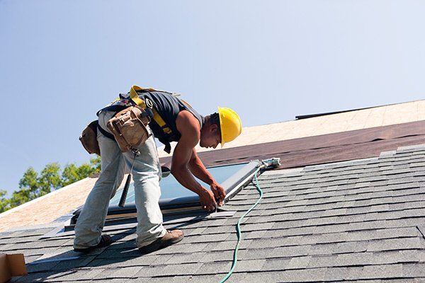 man installing skylight on roof