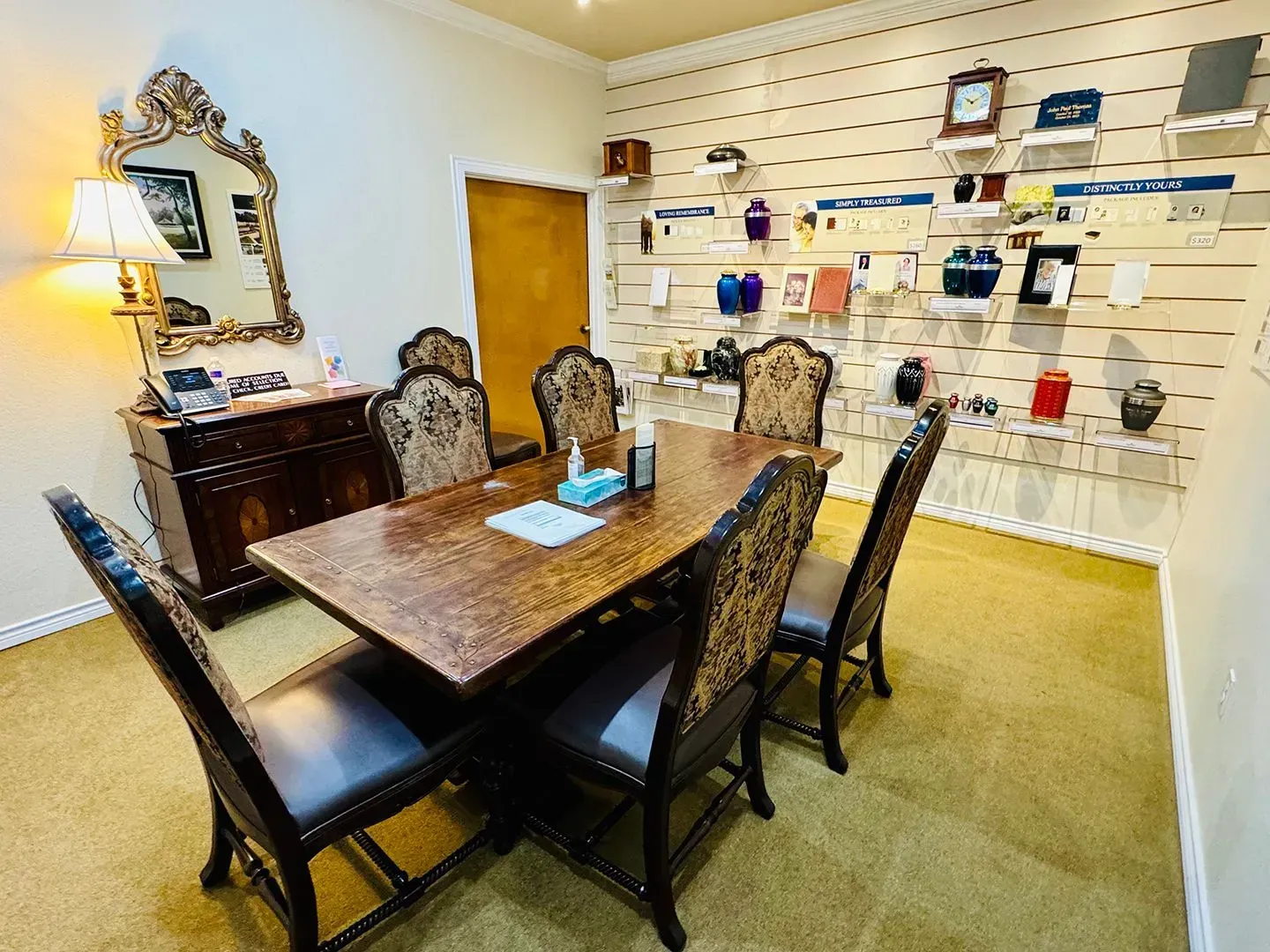 Large foyer with round wooden table, chandelier, and a vase of flowers.