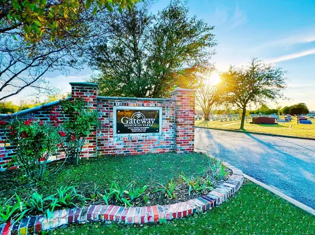 Rendering of a memorial with a central cross and surrounding structures, trees, and sky.