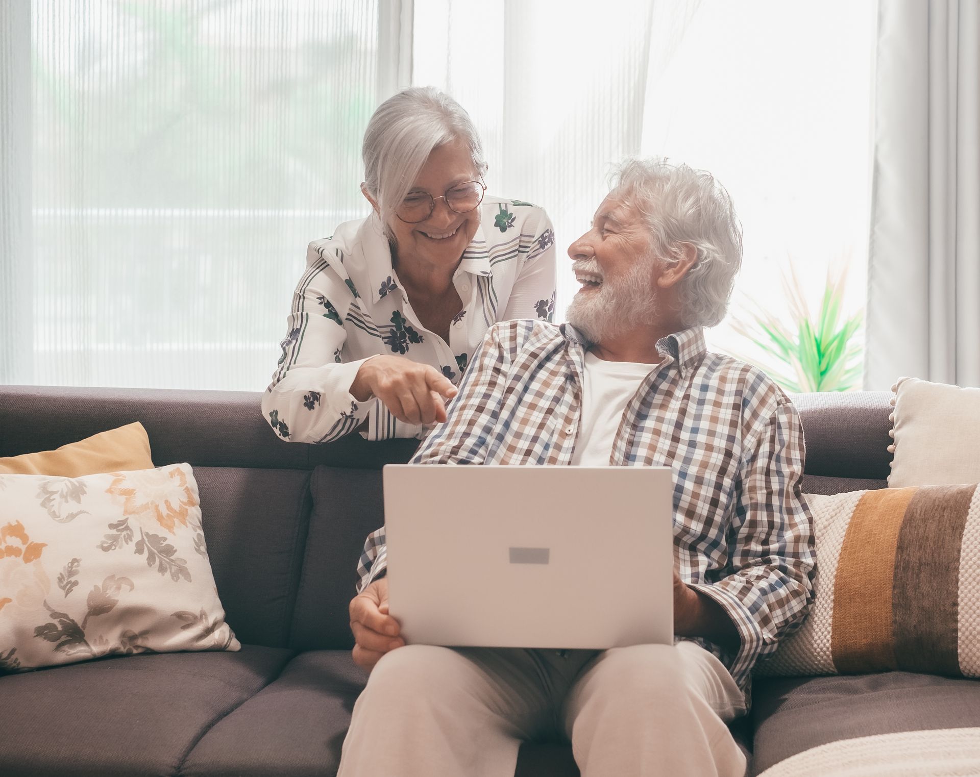 An elderly couple is dancing together in a kitchen.