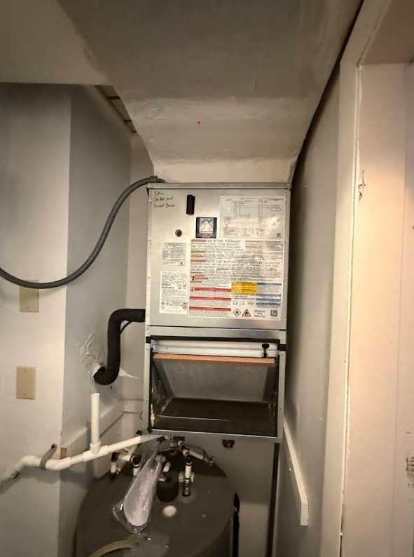 Furnace and water heater in a basement corner. White and gray appliances.