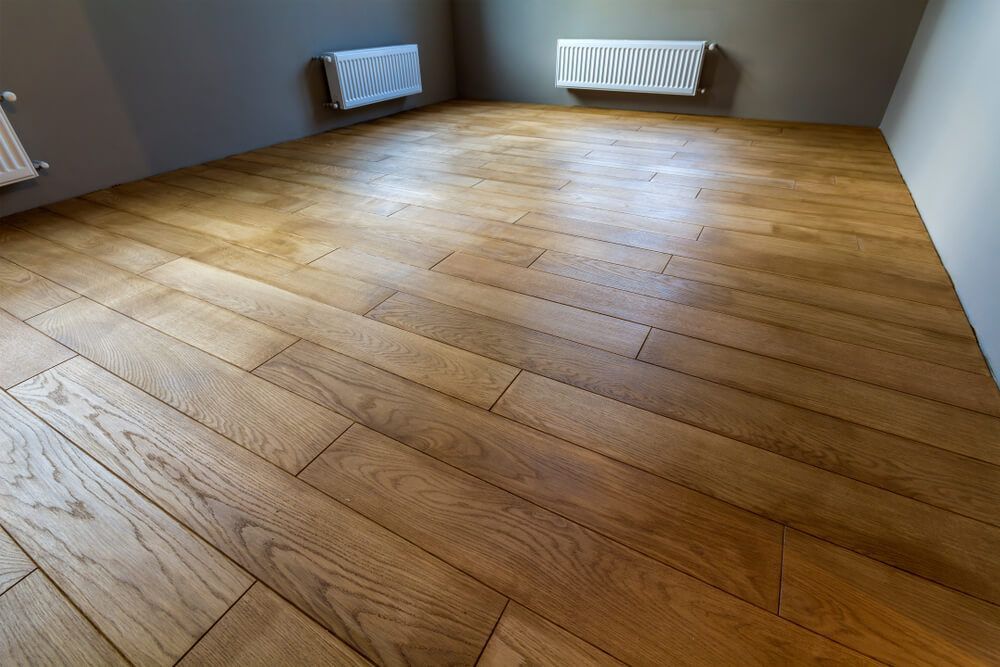 An Empty Room with A Wooden Floor and A Radiator — Lismore Floor Sanding in Murwillumbah, NSW