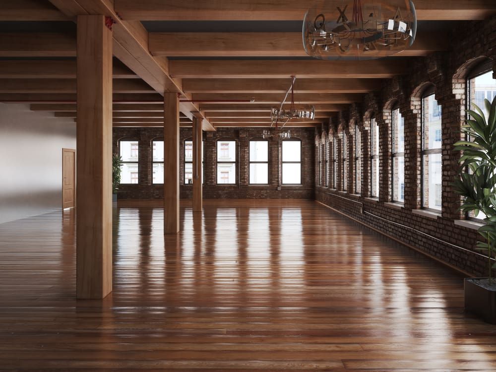 An Empty Room with A Lot of Windows and Wooden Floors — Lismore Floor Sanding in Evans Head, NSW