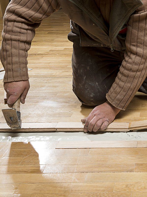 Worker Fixing Wooden Floor — Floor Repair in Lismore, NSW