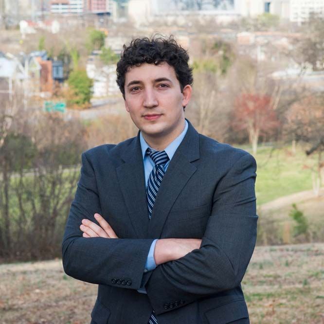 A man in a suit and tie with his arms crossed