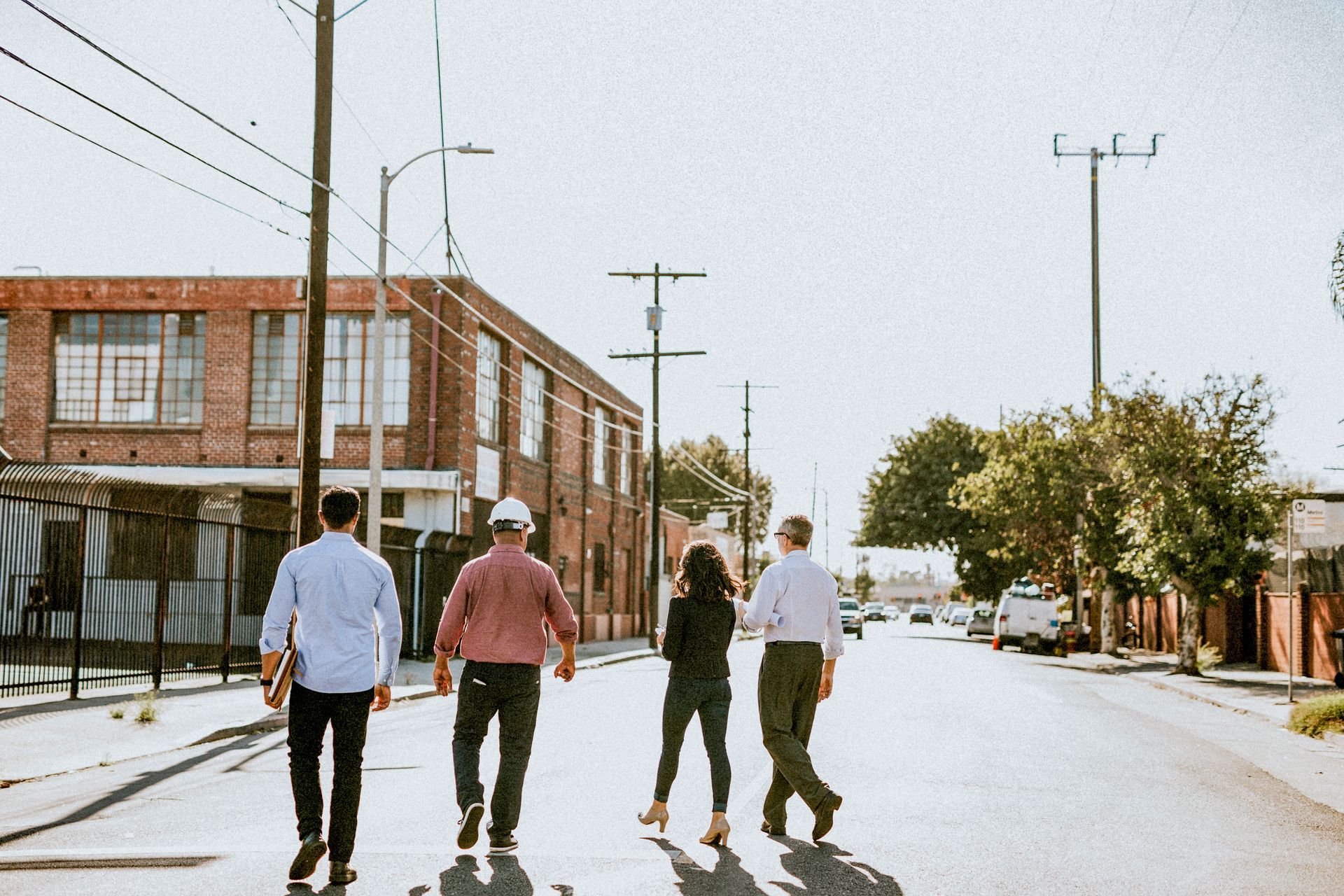 Family reads together on a couch, a girl smiles at a book. Others watch: grandparents and an older girl.