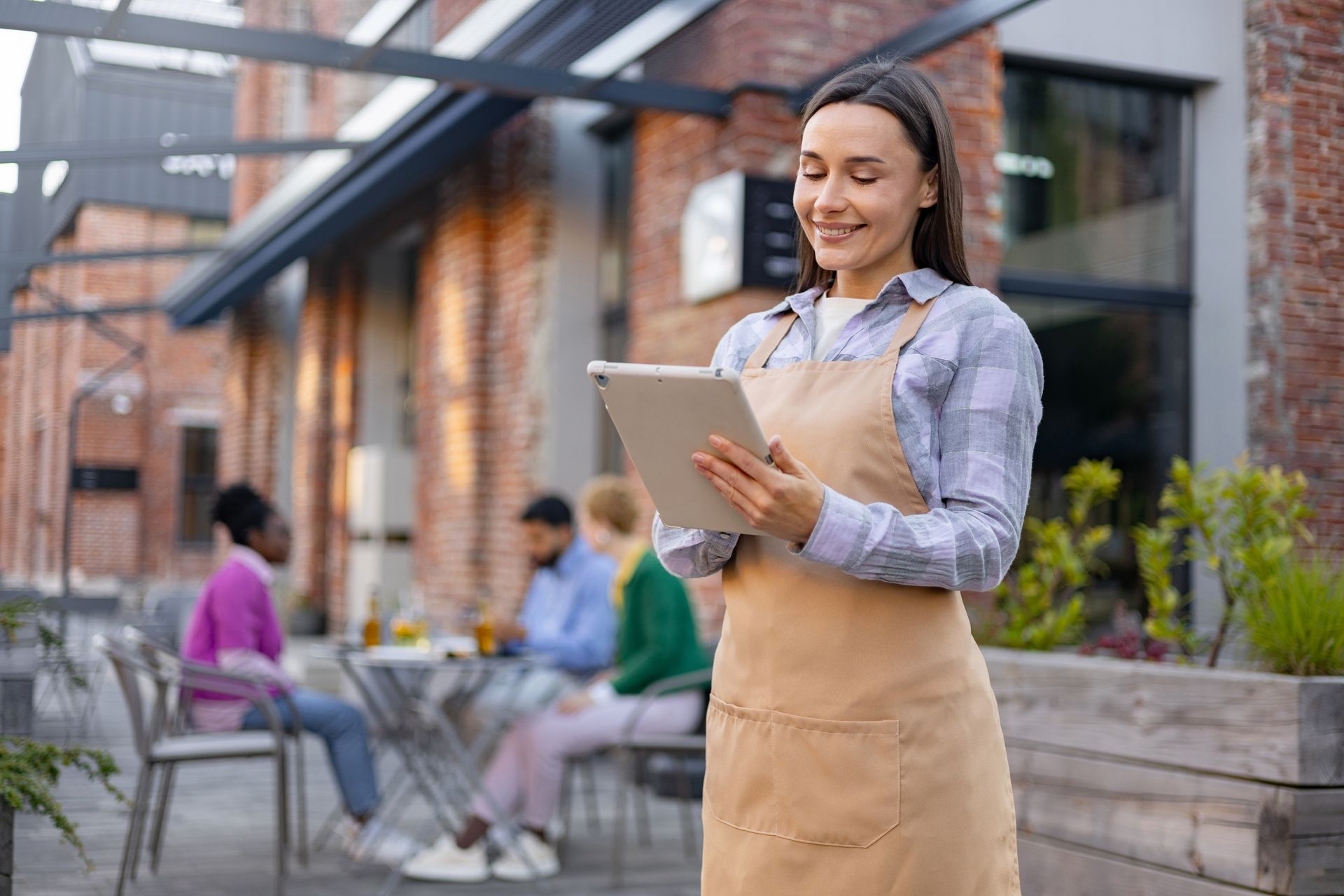 Family reads together on a couch, a girl smiles at a book. Others watch: grandparents and an older girl.