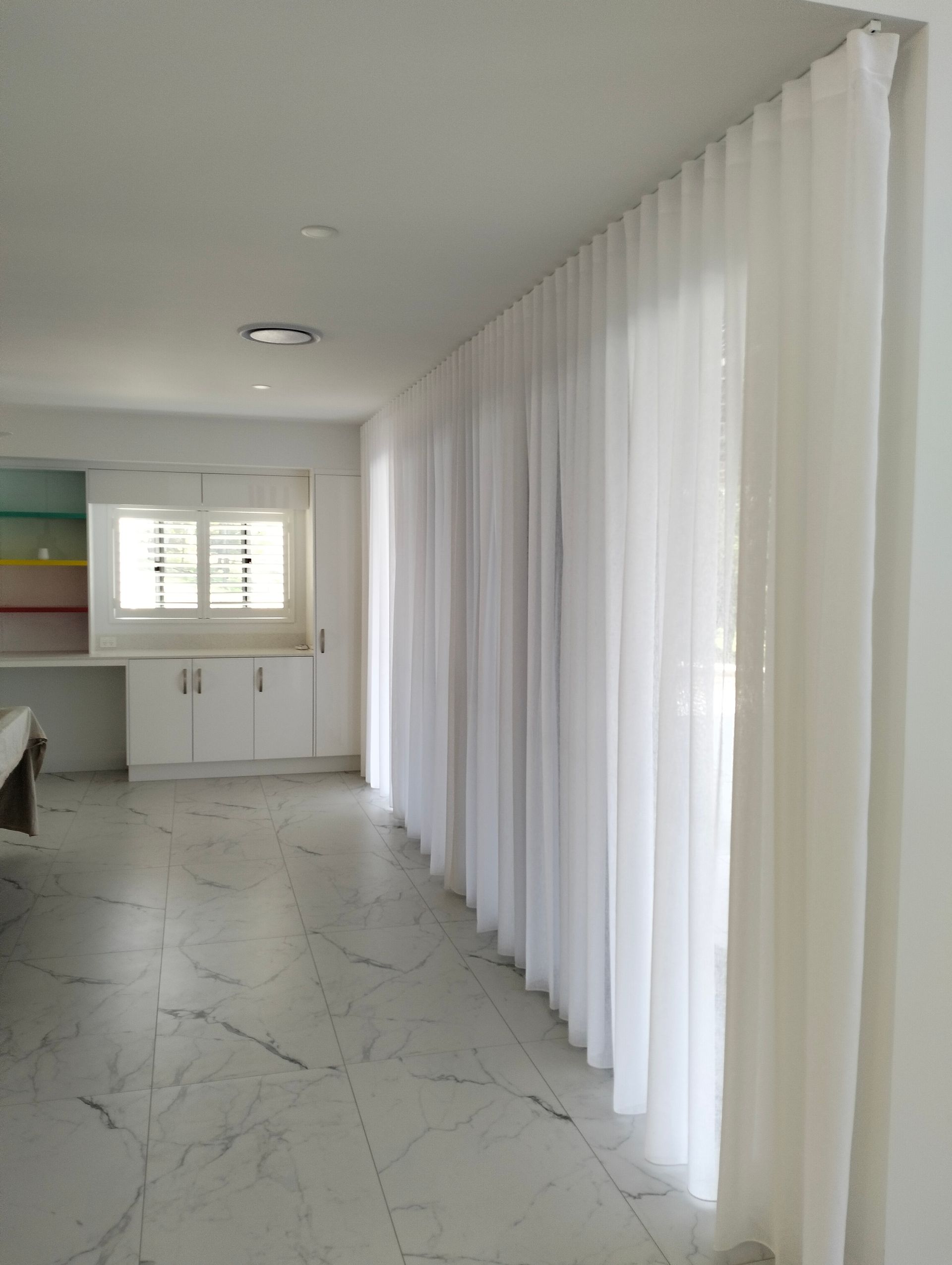 White Sheer Curtains Cover a Large Window in a Bright, Modern Room — Seaview Blinds & Shutters in Rockhampton, QLD