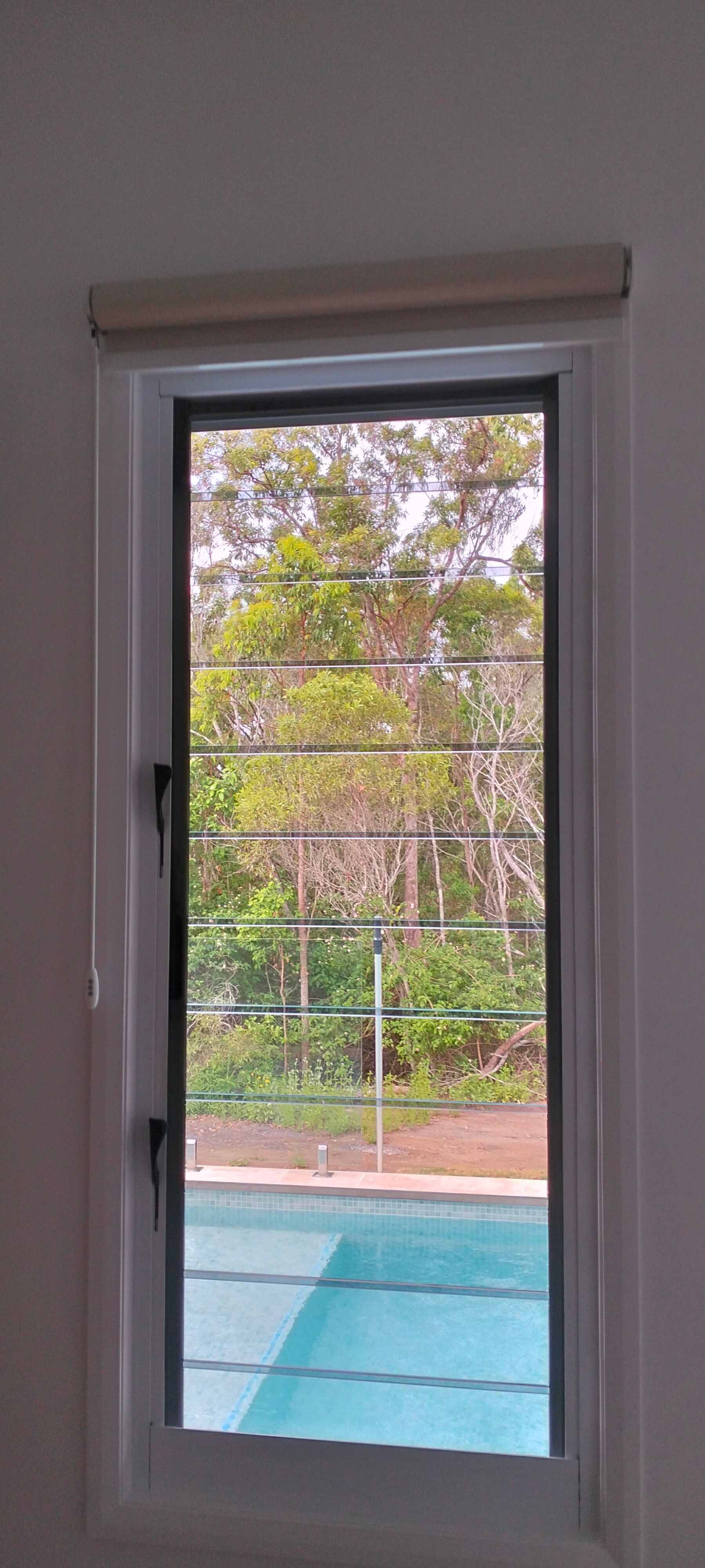 Person in Teal Scrubs Using a Remote Control to Adjust Blinds in Front of a Window — Seaview Blinds & Shutters in Woodbury, QLD