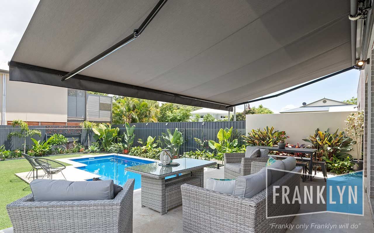 Patio With Retractable Awning, Outdoor Furniture, Pool, and a Backyard — Seaview Blinds & Shutters in Rockhampton, QLD
