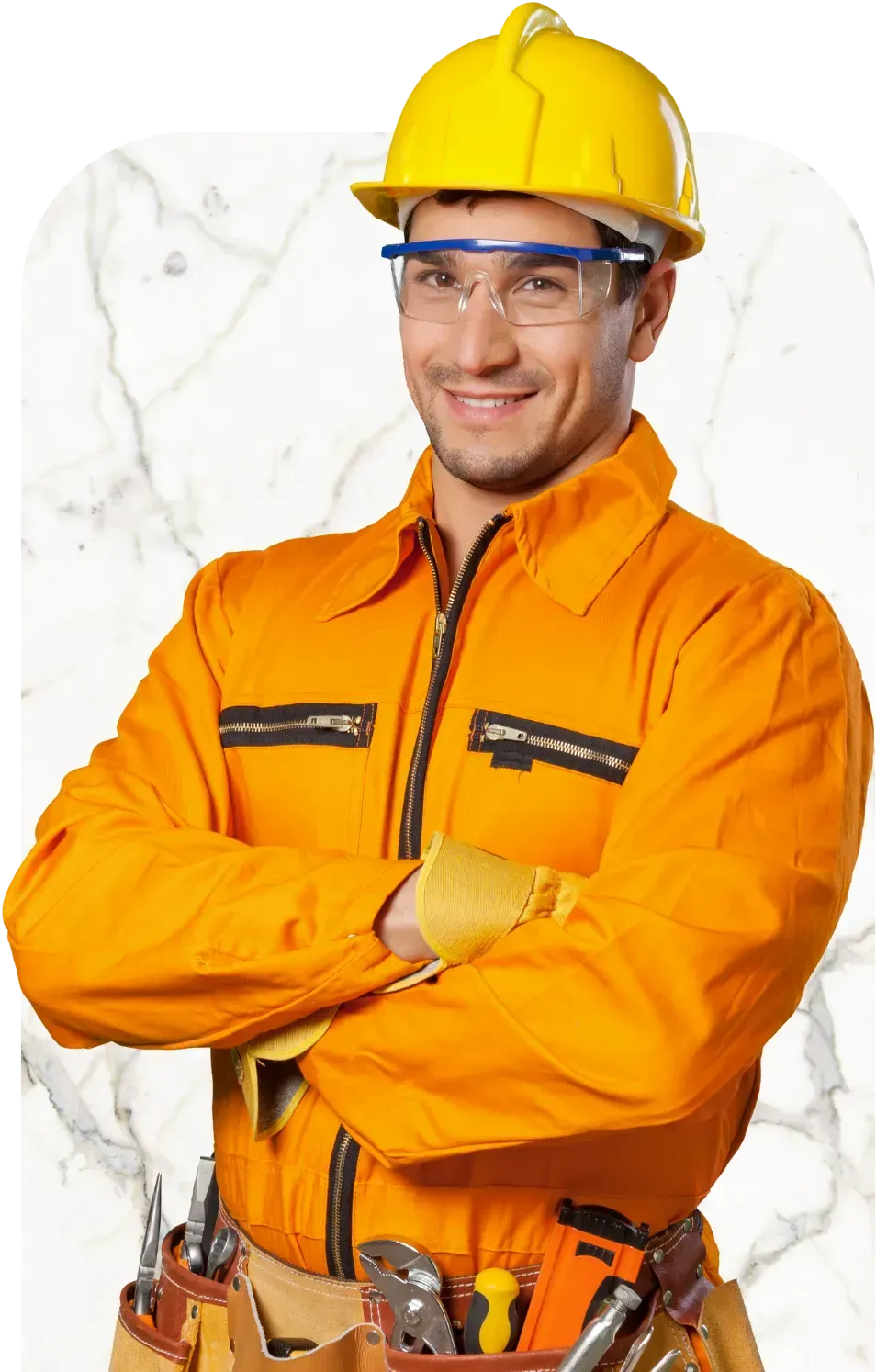 Construction worker in orange coveralls, yellow hard hat, and safety glasses, smiling with arms crossed.