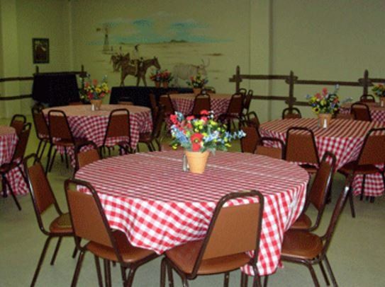 a room filled with tables and chairs with red and white checkered tables cloths