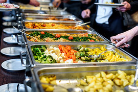 a buffet line filled with lots of different types of food .