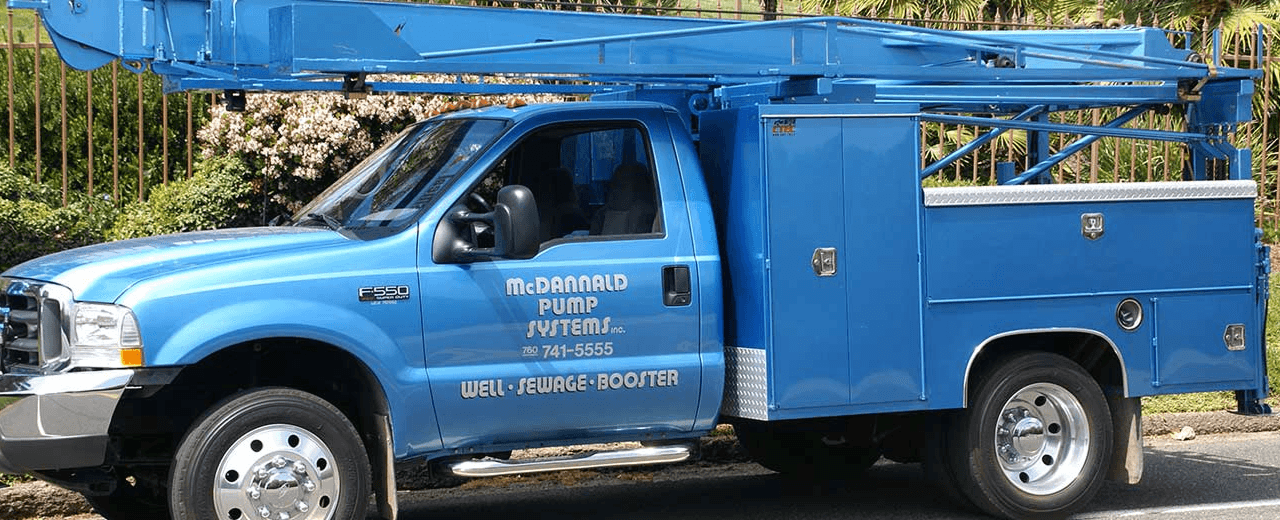 Blue industrial pumps and pipes with valves in a wet mechanical utility room