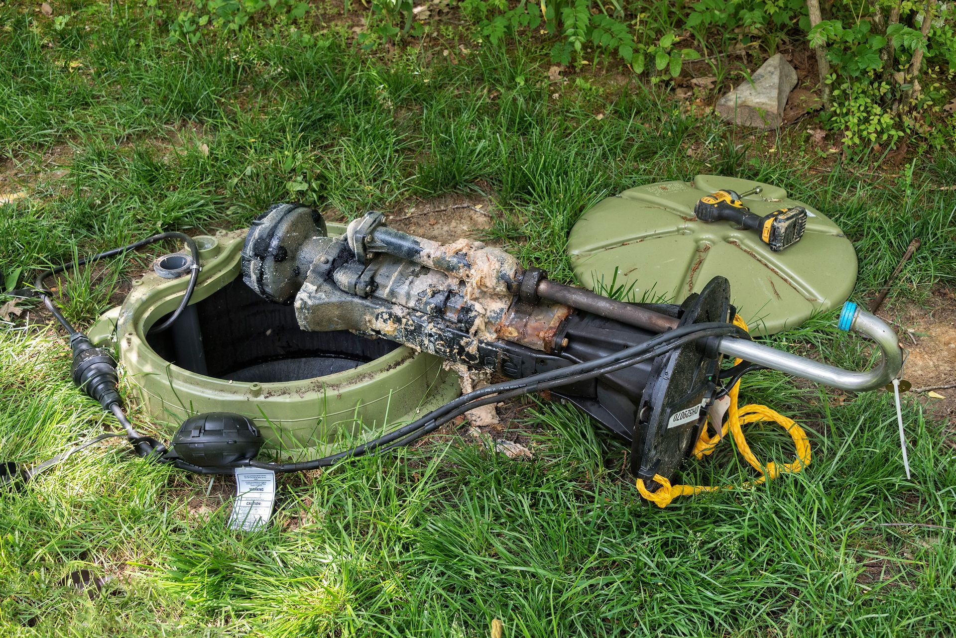 Overturned green car wheel with damaged suspension and debris in grass