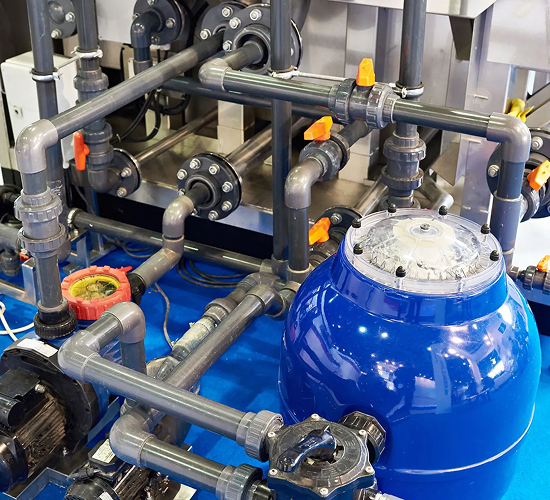 Industrial white pressure tank with attached motor and hoses in a storage facility