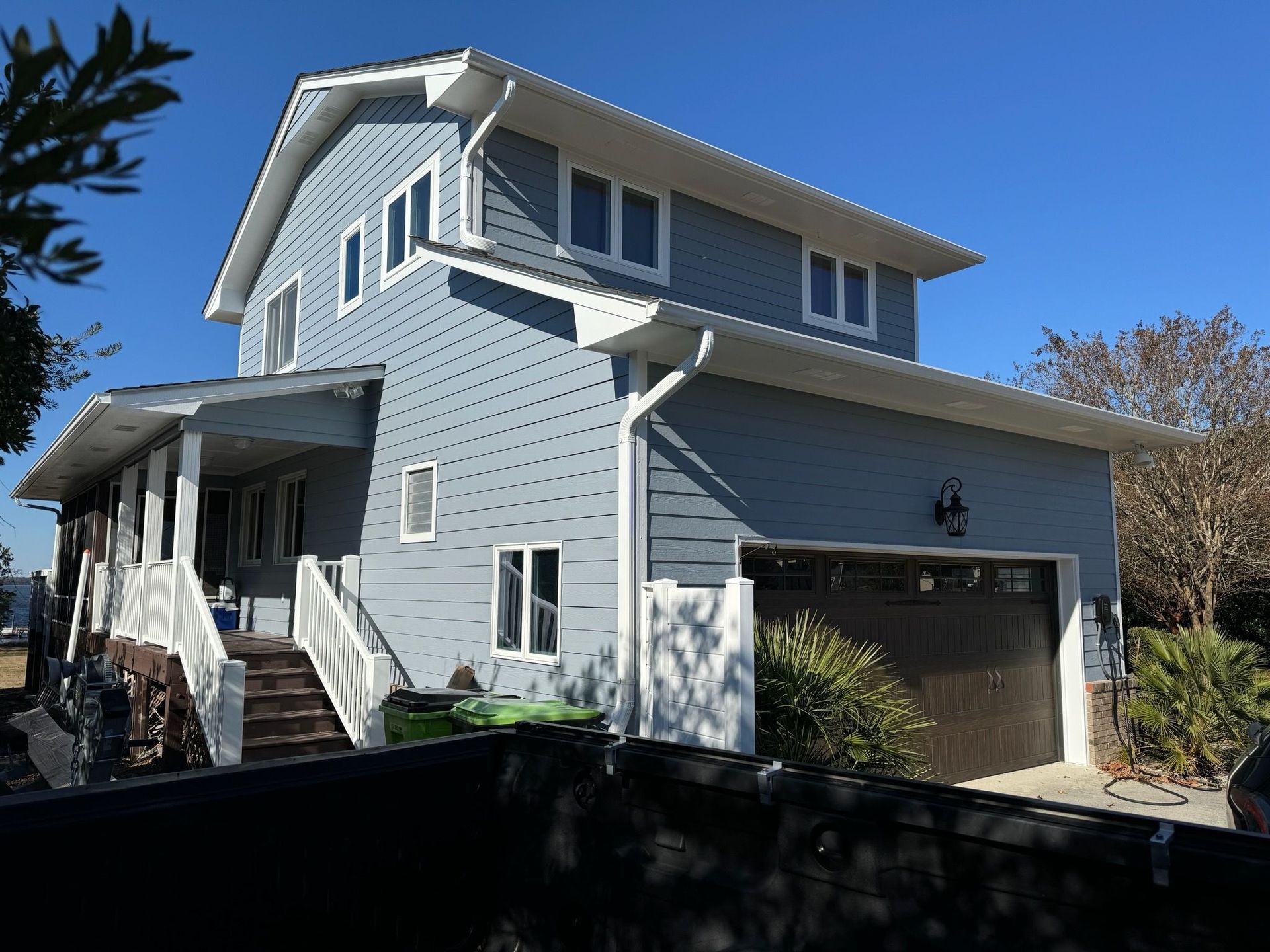 A large blue house with a garage and stairs