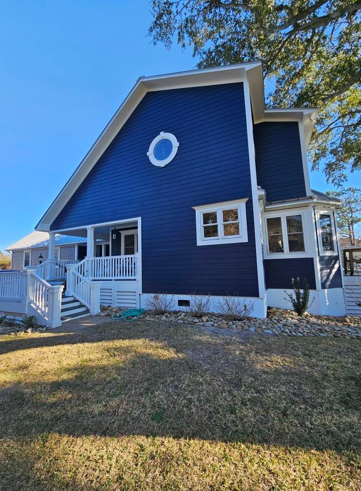 A large blue house with a white trim and a white porch.