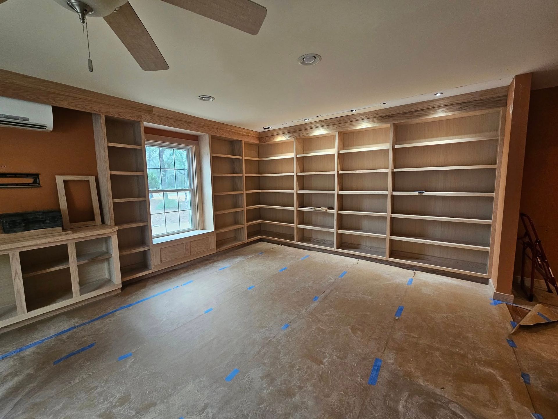 A large room with a lot of shelves and a ceiling fan.