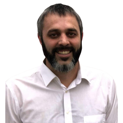 A man with a beard is wearing a white shirt and smiling