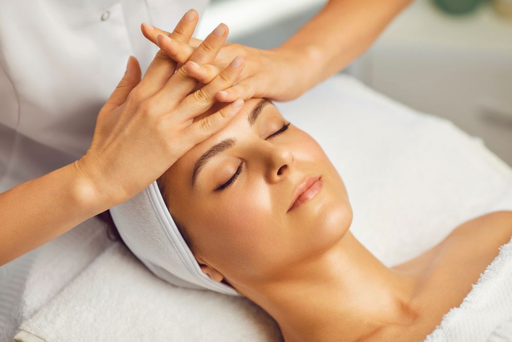 A Woman Is Getting a Facial Massage at A Spa — Brow & Lash Clinic In Cairns