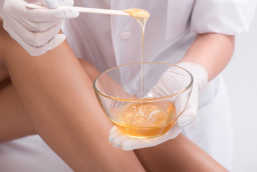 A Woman Is Getting a Waxing Treatment on Her Leg — Brow & Lash Clinic In Cairns
