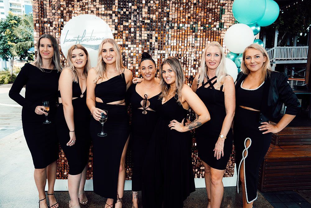 A Group of Women in Black Dresses Posing for a Picture — Brow & Lash Clinic In Cairns