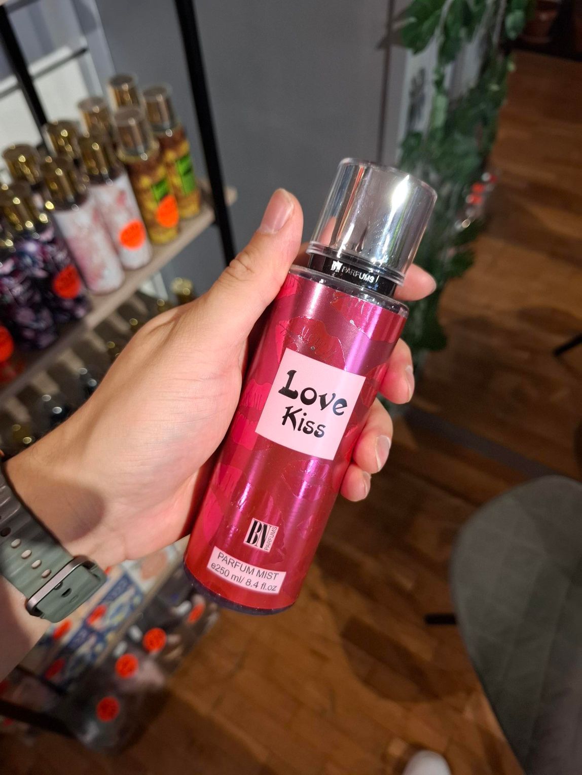 Een hand houdt een roze flesje 