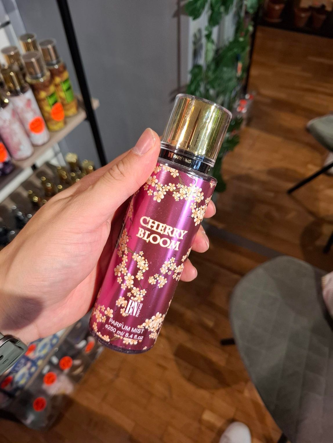 In een winkel houdt een hand een flesje 