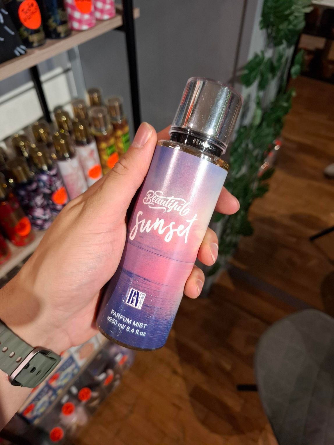 In een winkel houdt een hand een flesje 