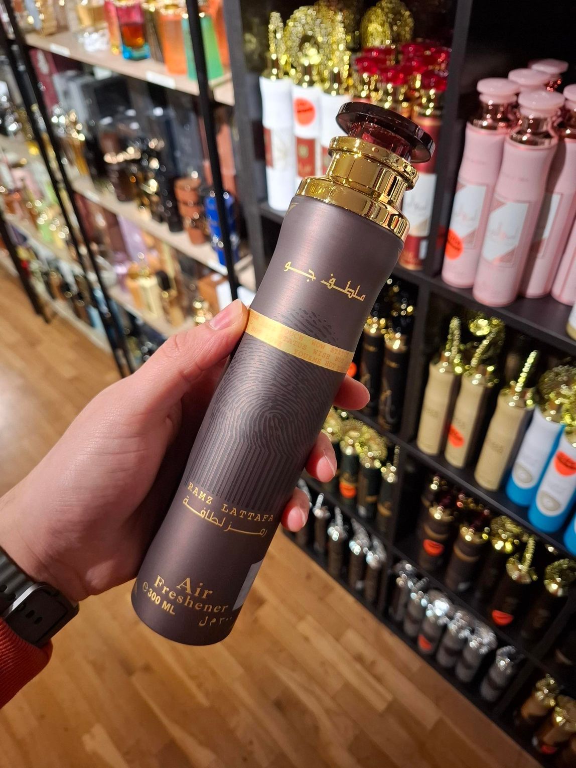 Een hand houdt een bruin-gouden busje 