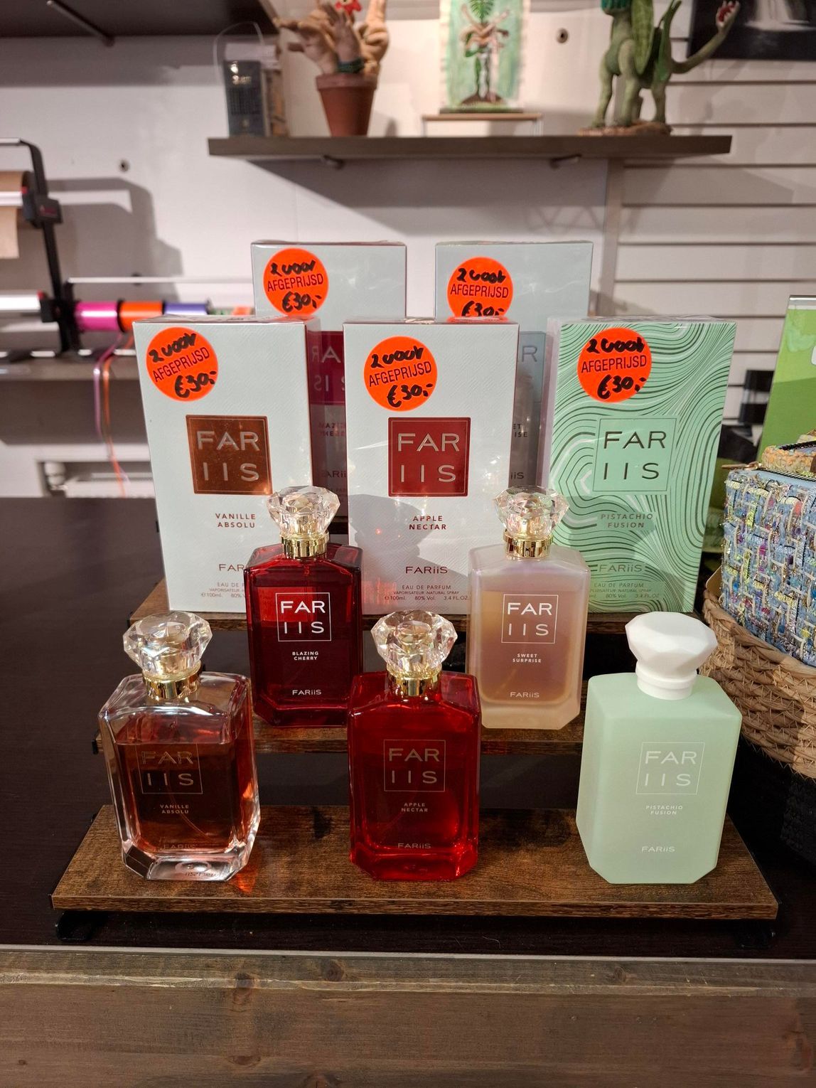 Vier flesjes Kayali-parfum in verschillende kleuren staan ​​uitgestald op een rond, grijs kleed van imitatiebont.