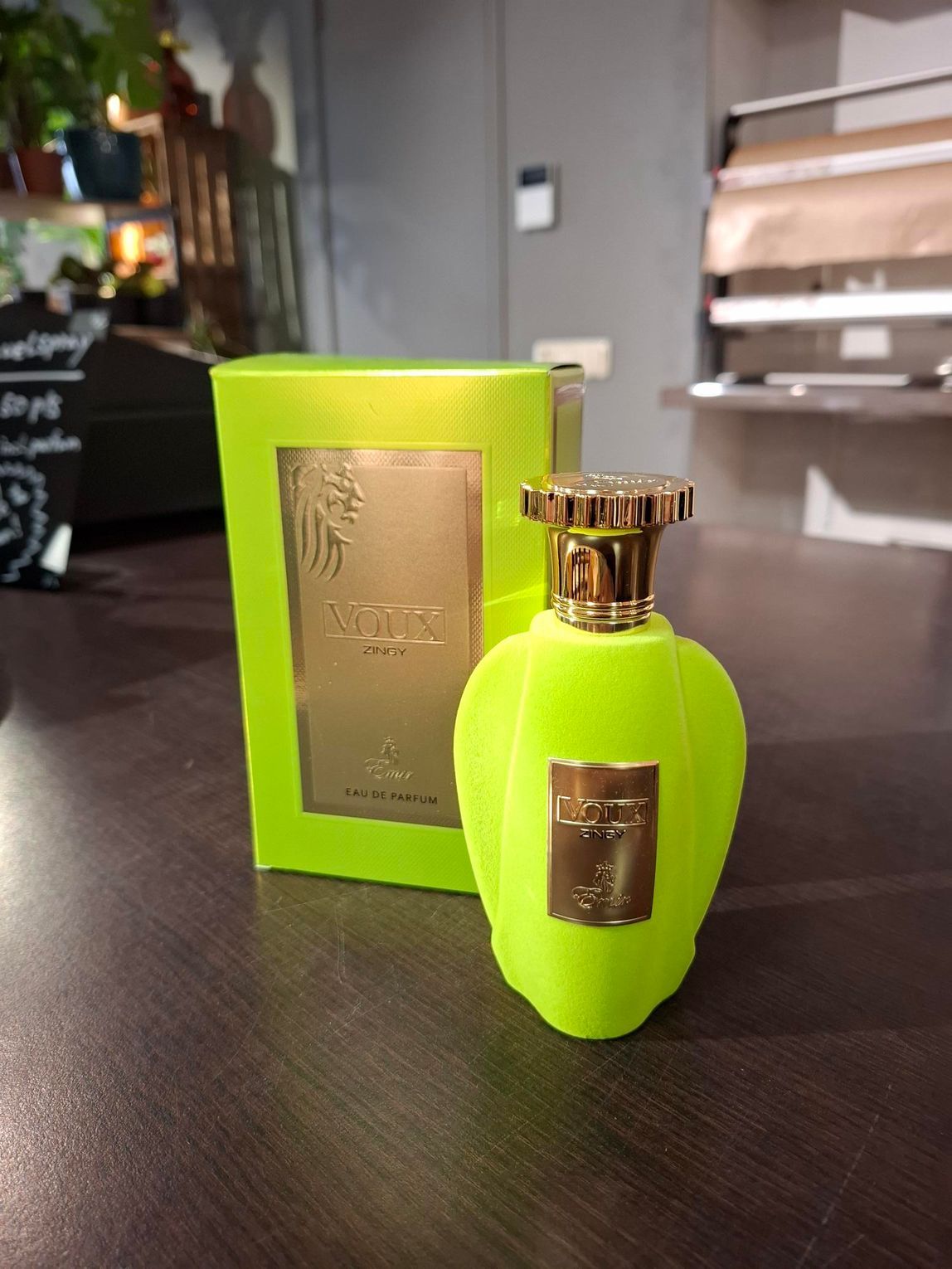 Een felgroene fles Xerjoff Sospiro-parfum staat naast de bijpassende doos op een donkere ondergrond.