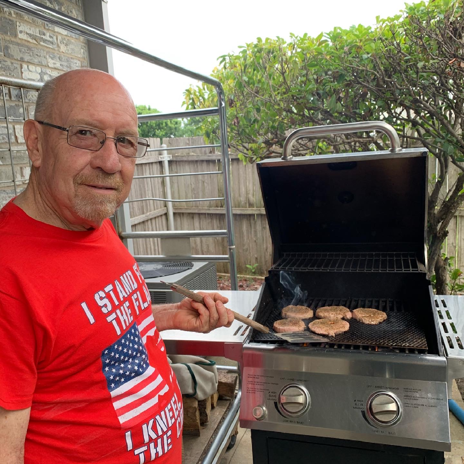 a man wearing a red shirt that says i stand in the flag