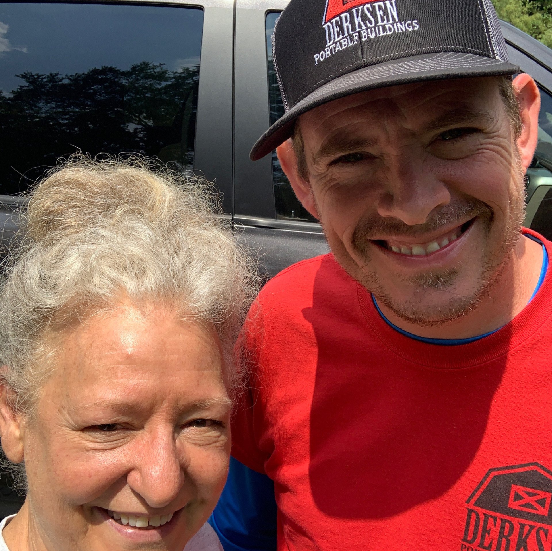 a man and a woman are posing for a picture and the man is wearing a derksen hat